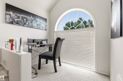 Arch-top window with blinds, vaulted ceiling, and carpeted flooring - 