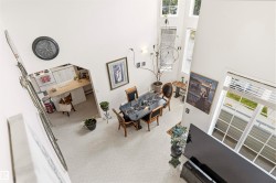 Two-story living area with high ceilings and tall windows - 