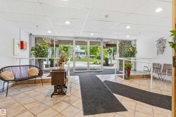 Welcoming lobby entrance featuring large glass doors, tile flooring, and a drop ceiling with recessed lighting - 