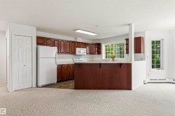 Open-concept kitchen with wood-finish cabinetry, light-toned countertops, and an integrated kitchen island - 