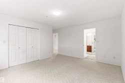 Spacious interior room featuring light-toned carpeting and white walls - 