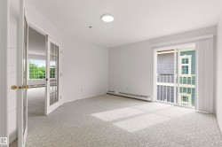 Bright room with light-colored patterned carpeting and white walls - 