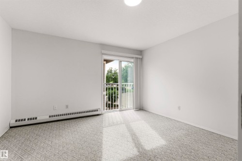 Bright room featuring light gray carpeting and white walls - #201 14 Mission Av, St. Albert, AB - Indoor Photo Showing Other Room