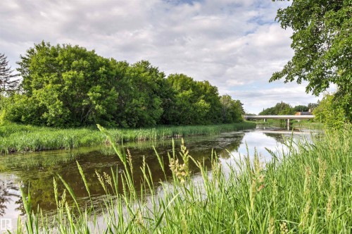 Natural waterway bordered by lush green foliage and tall grasses - #201 14 Mission Av, St. Albert, AB - Outdoor With View