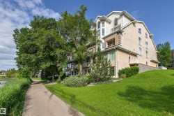 Multi-level residential building featuring stucco and brick exterior finishes, multiple balconies, and abundant natural light from numerous windows - 
