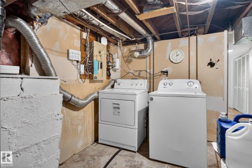 Dedicated laundry area featuring a white top-load washing machine and a white front-load dryer - 12703 122 Street Nw, Edmonton, AB 