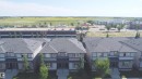 Row of two-story residences featuring light gray siding and dark gray shingle roofing - 187 Radcliffe Wynd, Fort Saskatchewan, AB  - Outdoor 