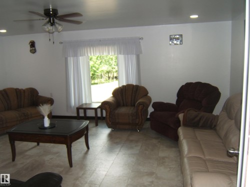 Spacious living area featuring light-toned tile flooring, recessed ceiling lighting, and a ceiling fan with integrated illumination - 543016 Rng Rd 122, Rural Two Hills County, AB - Indoor Photo Showing Living Room