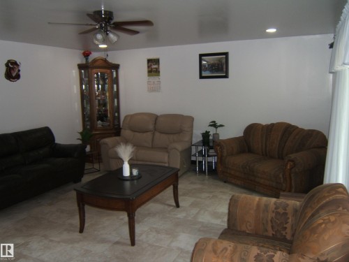 Spacious living area featuring light-toned tile flooring, recessed lighting, a ceiling fan with integrated lighting, and white walls - 543016 Rng Rd 122, Rural Two Hills County, AB - Indoor Photo Showing Living Room