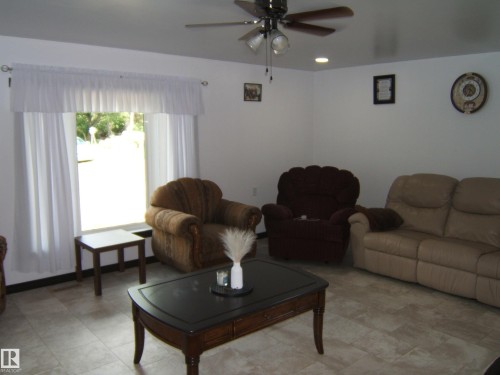 Spacious room featuring neutral-toned tile flooring, a large window with white treatments, and recessed lighting - 543016 Rng Rd 122, Rural Two Hills County, AB - Indoor Photo Showing Living Room