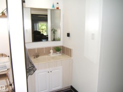 Bathroom vanity with integrated sink, chrome faucet, and white cabinet storage - 