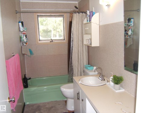Bathroom featuring a green bathtub, tiled shower surround, and a single window - 543016 Rng Rd 122, Rural Two Hills County, AB - Indoor Photo Showing Bathroom