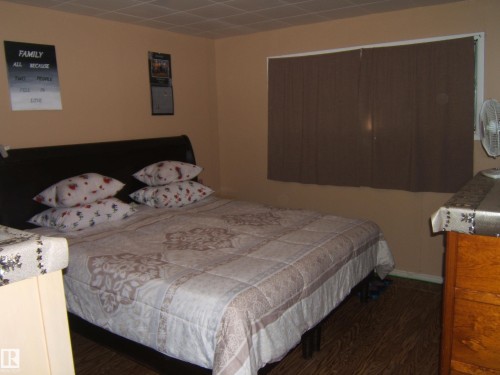 Bedroom featuring wood-finish flooring, neutral wall tones, and a window with blinds - 543016 Rng Rd 122, Rural Two Hills County, AB - Indoor Photo Showing Bedroom