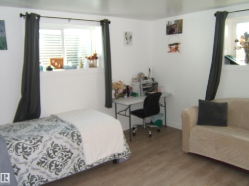 Crisp white walls frame this room featuring wood-finish flooring - 543016 Rng Rd 122, Rural Two Hills County, AB - Indoor Photo Showing Bedroom