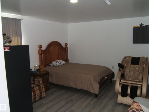 Room featuring wood-finish flooring, white painted walls, and a recessed ceiling light - 543016 Rng Rd 122, Rural Two Hills County, AB - Indoor Photo Showing Bedroom