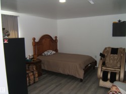Room featuring wood-finish flooring, white painted walls, and a recessed ceiling light - 