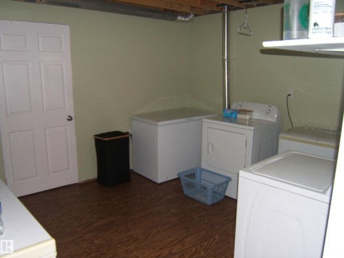 Utility area featuring wood-finish flooring and light green walls - 543016 Rng Rd 122, Rural Two Hills County, AB - Indoor Photo Showing Laundry Room