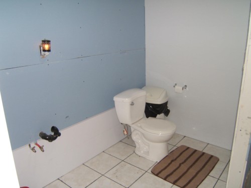 Bathroom featuring a white toilet, light-colored tile flooring, and a wall-mounted light fixture - 543016 Rng Rd 122, Rural Two Hills County, AB - Indoor Photo Showing Bathroom