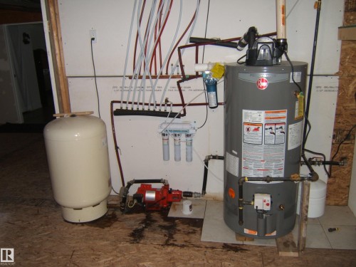 Water heater system featuring a pressure tank, water filtration units, and a water pump - 543016 Rng Rd 122, Rural Two Hills County, AB - Indoor Photo Showing Basement