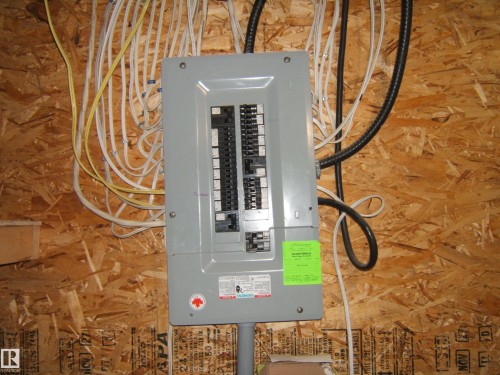 Electrical service panel mounted on an oriented strand board wall - 543016 Rng Rd 122, Rural Two Hills County, AB - Indoor Photo Showing Basement