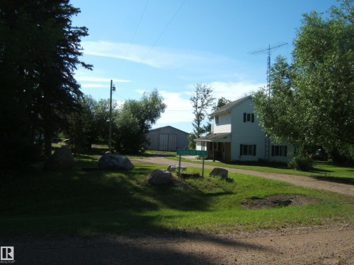 Two-story residence with white siding and dark shutters, featuring a covered front porch - 543016 Rng Rd 122, Rural Two Hills County, AB - Outdoor