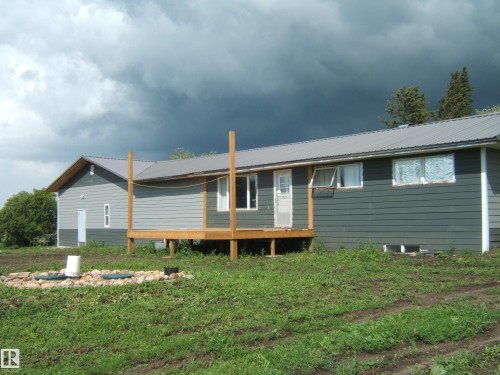 Ranch-style residence featuring a gray metal roof and horizontal siding - 543016 Rng Rd 122, Rural Two Hills County, AB - Outdoor