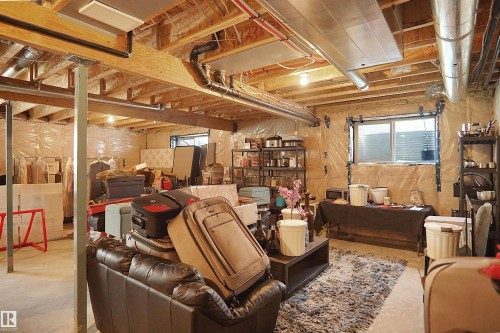 Unfinished basement space featuring exposed wood joists, structural support beams, and visible ductwork - 5802 Soleil Boulevard, Beaumont, AB 