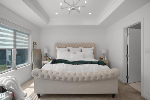 Spacious room featuring a tray ceiling with recessed lighting and a contemporary chandelier - 5802 Soleil Boulevard, Beaumont, AB 
