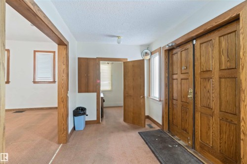 Entryway with panel doors, side-light window, and built-in wood-finish cabinetry - 13156 101 St Nw, Edmonton, AB 