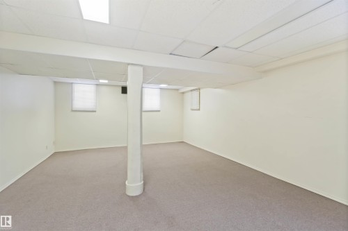 Spacious room featuring neutral carpeting and light-colored walls - 13156 101 St Nw, Edmonton, AB 