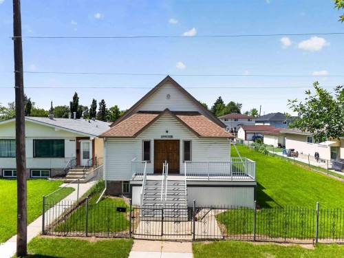 Gable-roof property featuring white siding and a prominent front entry with double wood doors - 13156 101 St Nw, Edmonton, AB 
