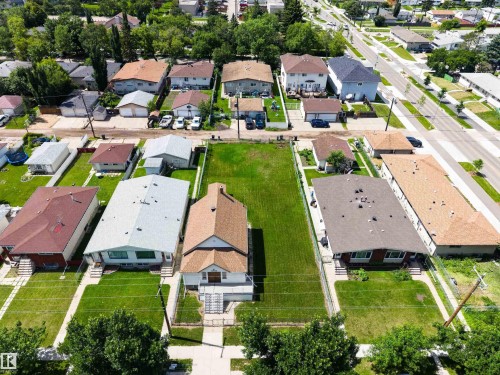 Aerial perspective showcasing a residential property with a central building and expansive grassy areas - 13156 101 St Nw, Edmonton, AB 