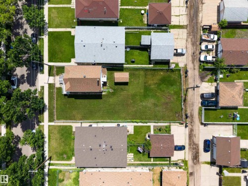 Aerial perspective showcasing multiple residential properties with varied roof colors and surrounding green spaces - 13156 101 St Nw, Edmonton, AB 