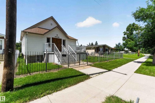 White vinyl-sided structure featuring a gable roof and visible foundation - 13156 101 St Nw, Edmonton, AB 