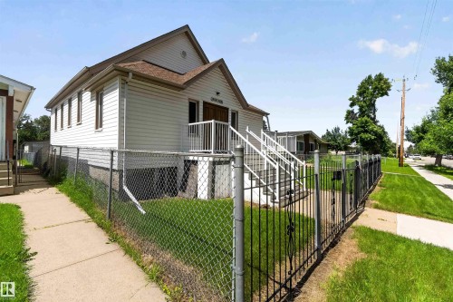 White-sided exterior with a brown shingle roof and multiple windows - 13156 101 St Nw, Edmonton, AB 