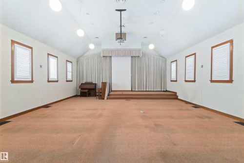 Spacious room featuring vaulted ceilings, recessed lighting, and a raised platform - 13156 101 St Nw, Edmonton, AB 