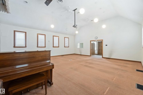 Spacious room featuring vaulted ceilings, recessed lighting, and multiple windows with blinds - 13156 101 St Nw, Edmonton, AB 