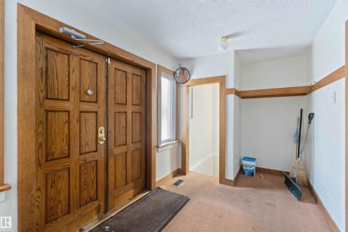 Double wood entry doors with paneled detailing, side window, and built-in coat rack - 13156 101 St Nw, Edmonton, AB 