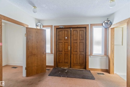 Double panel wood entry doors with side windows and natural wood trim accents - 13156 101 St Nw, Edmonton, AB 