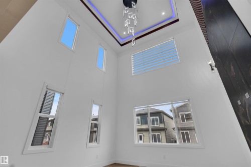 Vaulted ceiling with an illuminated tray detail and modern chandelier - 3604 44 Avenue, Beaumont, AB -  Photo Showing Other Room