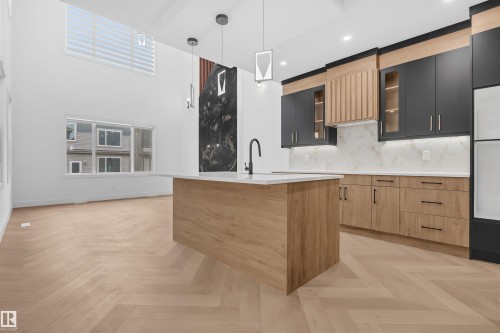 Kitchen featuring a central island with a white countertop and integrated sink - 3604 44 Avenue, Beaumont, AB - Indoor Photo Showing Kitchen
