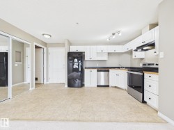 Kitchen area featuring white cabinetry, dark countertops, and tile flooring - 
