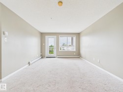 Spacious room featuring neutral carpeting, light-toned walls, and a white trim finish - 