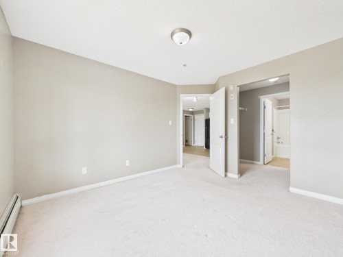Carpeted interior space featuring light neutral wall paint - #309 5350 199 St Nw, Edmonton, AB 