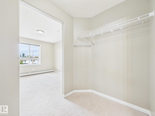 Corner closet with wire shelving and hanging rod - #309 5350 199 St Nw, Edmonton, AB 