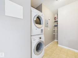 Dedicated laundry area with stacked appliances, checkered tile flooring, and neutral wall tones - 