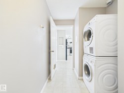 Dedicated laundry area featuring stacked appliances and tile flooring - 