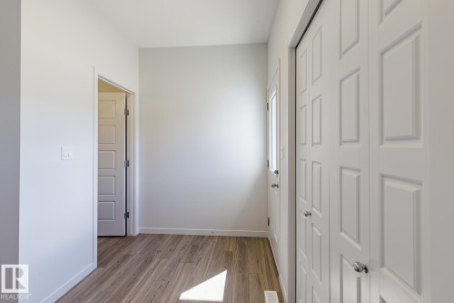 Entryway featuring wood-finish flooring, white walls, and bright white trim - 3619 Triomphe Boulevard, Beaumont, AB - Indoor Photo Showing Other Room