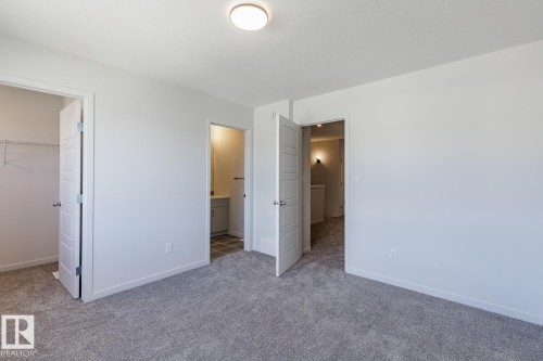 Carpeted room with white walls, a flush-mount ceiling light, and white baseboards - 3619 Triomphe Boulevard, Beaumont, AB - Indoor