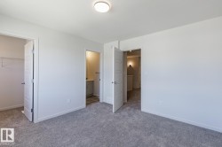 Carpeted room with white walls, a flush-mount ceiling light, and white baseboards - 